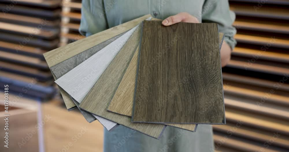 flooring store seller with vinyl floor samples in hands