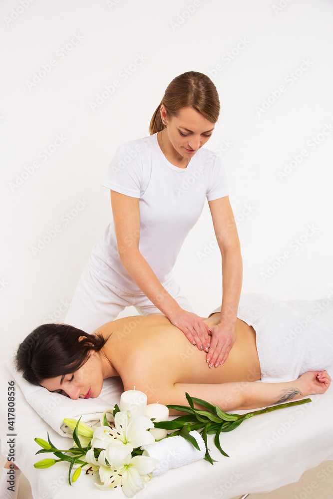 Masseur doing massage on woman body. Beautiful young woman in spa salon. Spa concept