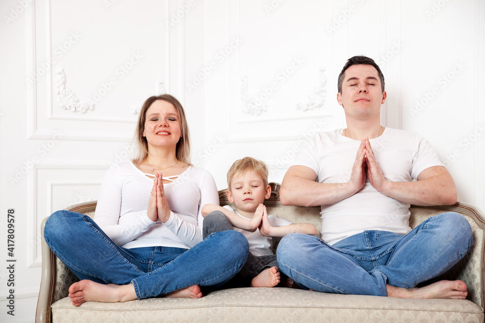 Family with son in yoga pose on sofa Family with son in yoga pose on sofa