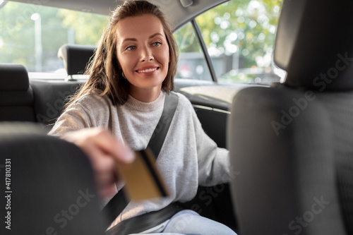 transportation, vehicle and payment concept - female passenger giving credit card to taxi driver © Syda Productions