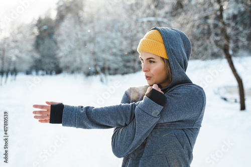 Young athletic woman warming up before her winter workout photo