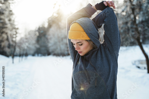 Young athletic woman warming up before her winter workout