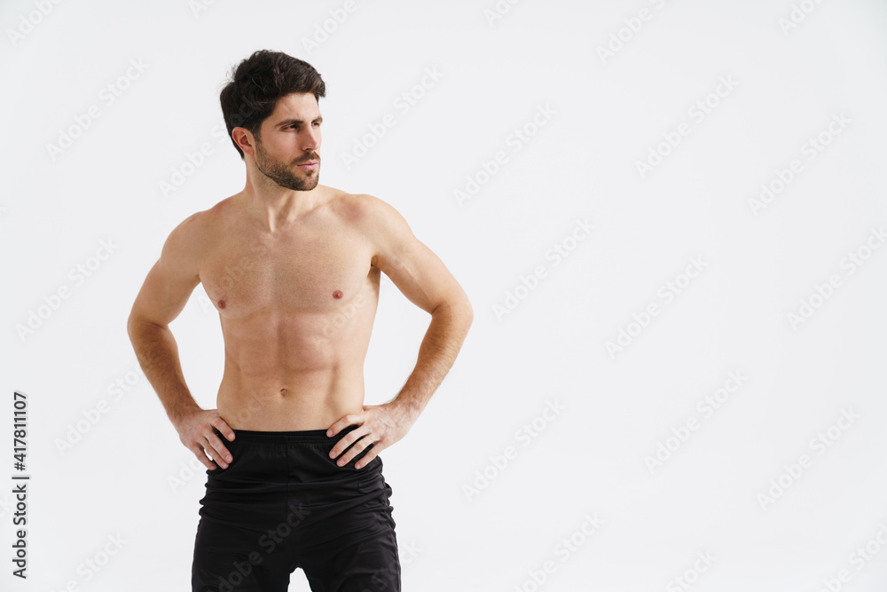 Shirtless athletic sportsman posing and looking aside Shirtless athletic sportsman posing and looking aside