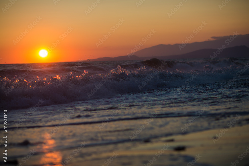 beautiful sunset by the sea with strong waves