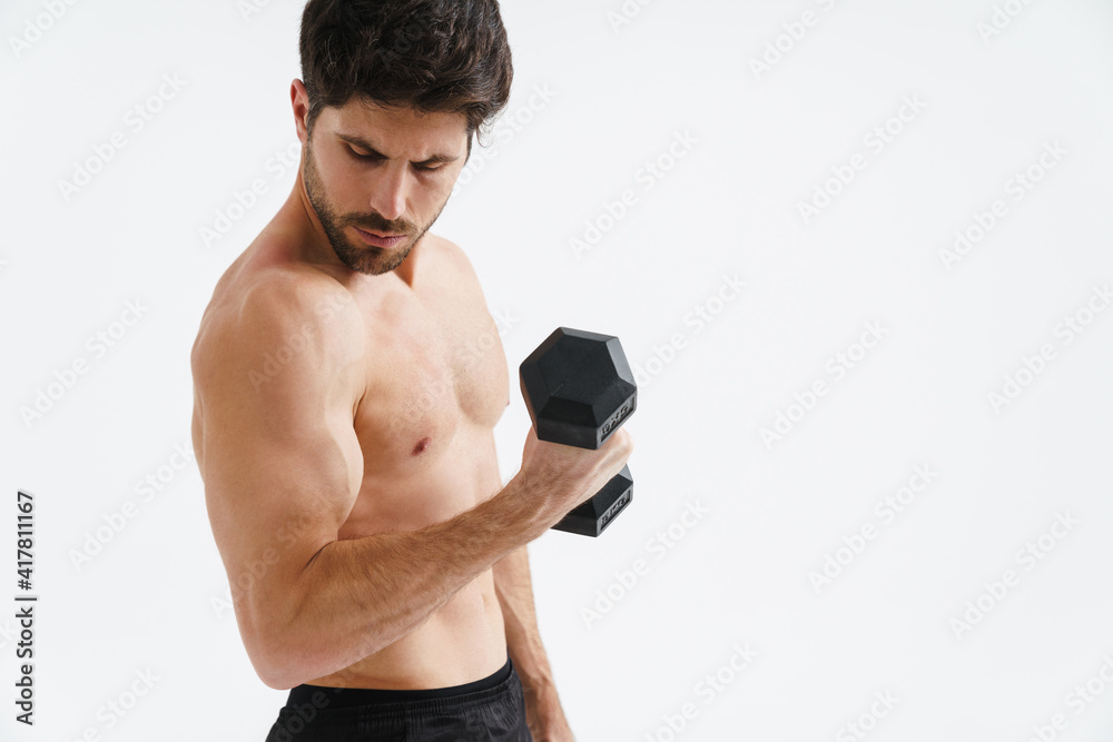 Fototapeta premium Half-naked athletic sportsman working out with dumbbell