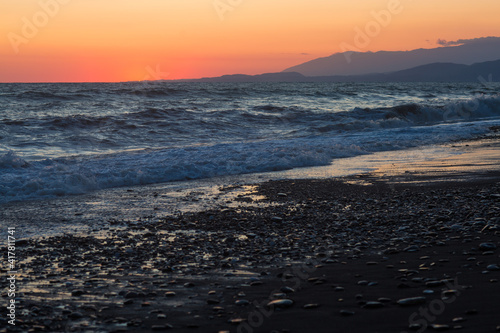 beautiful sunset by the sea with strong waves