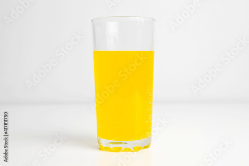 Glass of juice with gases standing on the table indoors  close-up