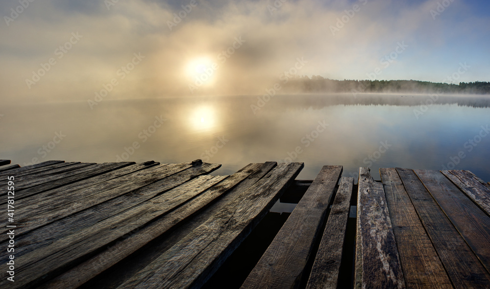 Panorama landscape view of misty sunrise in beautiful lake surrounded by forest