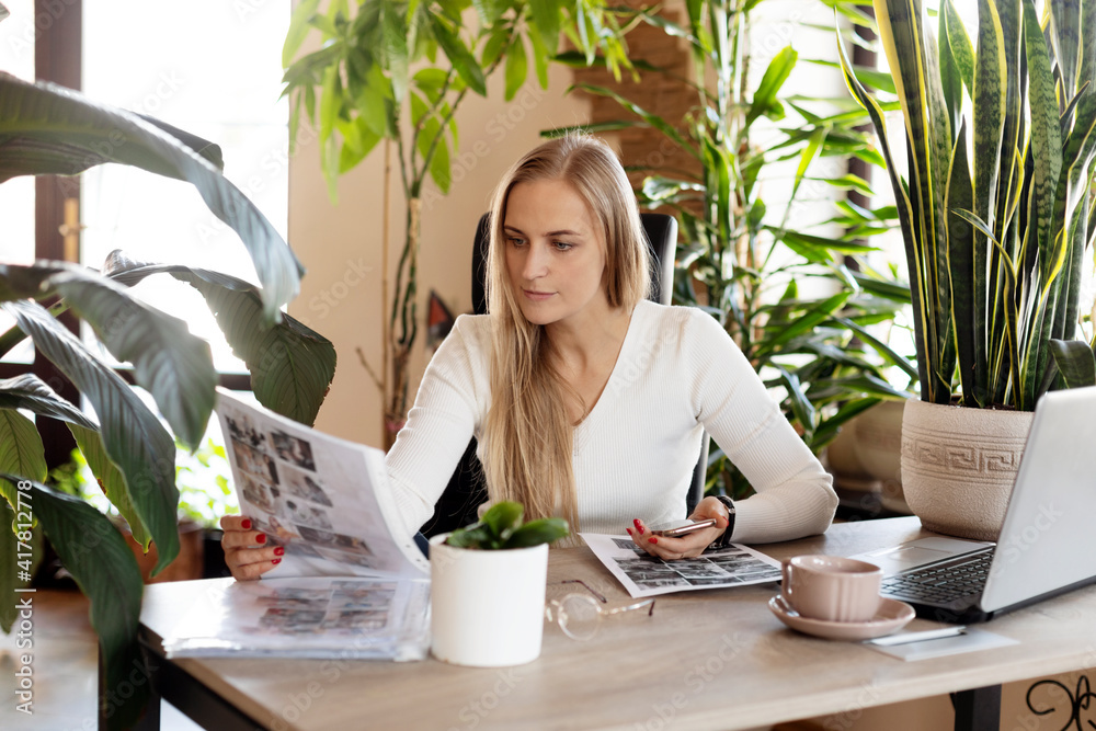 A young woman looks through documents while working in the office A young woman looks through documents while working in the office