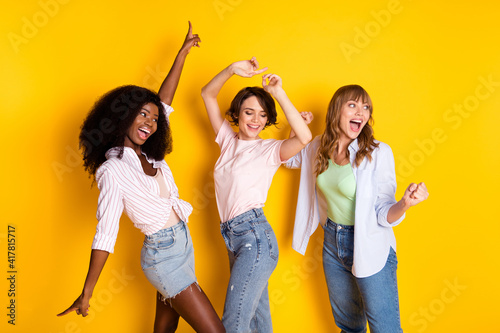 фотографія Portrait of three attractive cheerful girls dancing having fun rejoicing rest is