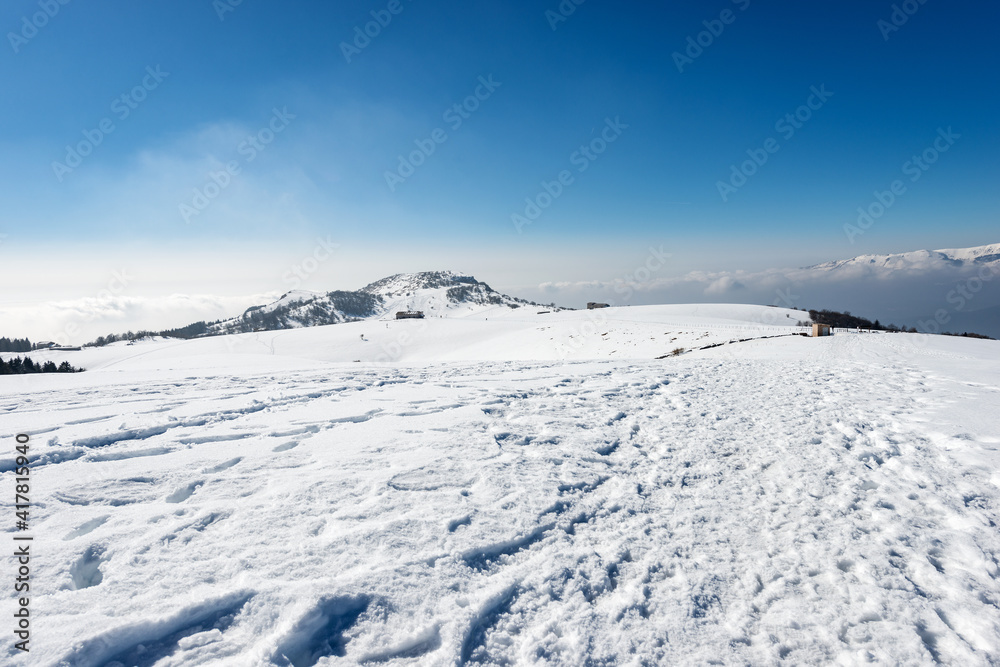 Mountain peak of Corno d'Aquilio in winter with snow. Lessinia Plateau (Altopiano della Lessinia), Regional Natural Park. Monte Baldo on the right. Sant'Anna d'Alfaedo, Verona province, Veneto, Italy. Mountain peak of Corno d'Aquilio in winter with snow. Lessinia Plateau (Altopiano della Lessinia), Regional Natural Park. Monte Baldo on the right. Sant'Anna d'Alfaedo, Verona province, Veneto, Italy.
