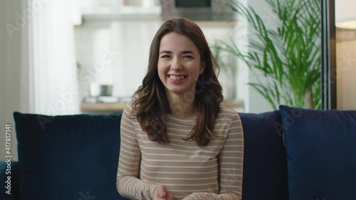 Happy young woman laughing, making thumbs up gesture to web camera, making distance online video conference call 