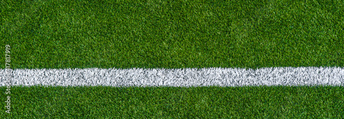 Green synthetic grass sports field with white line shot from above. Sports background for product display, banner, or mockup.