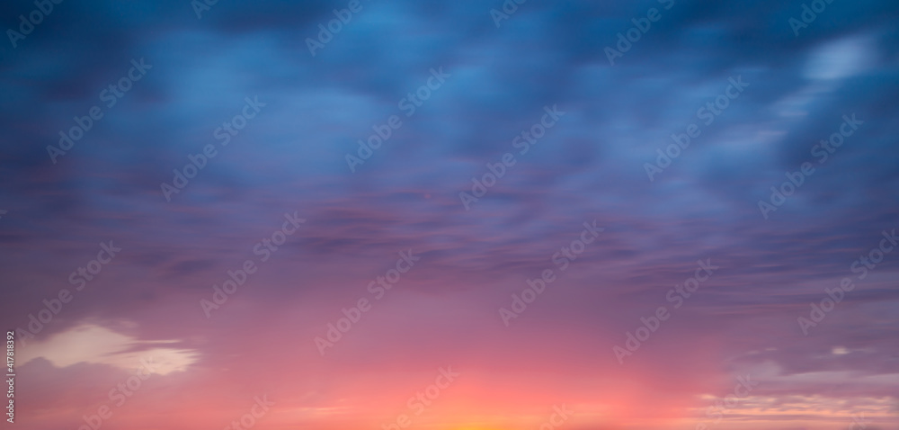 Pink and blue dramatic sky with clouds at sunset, panoramic nature background