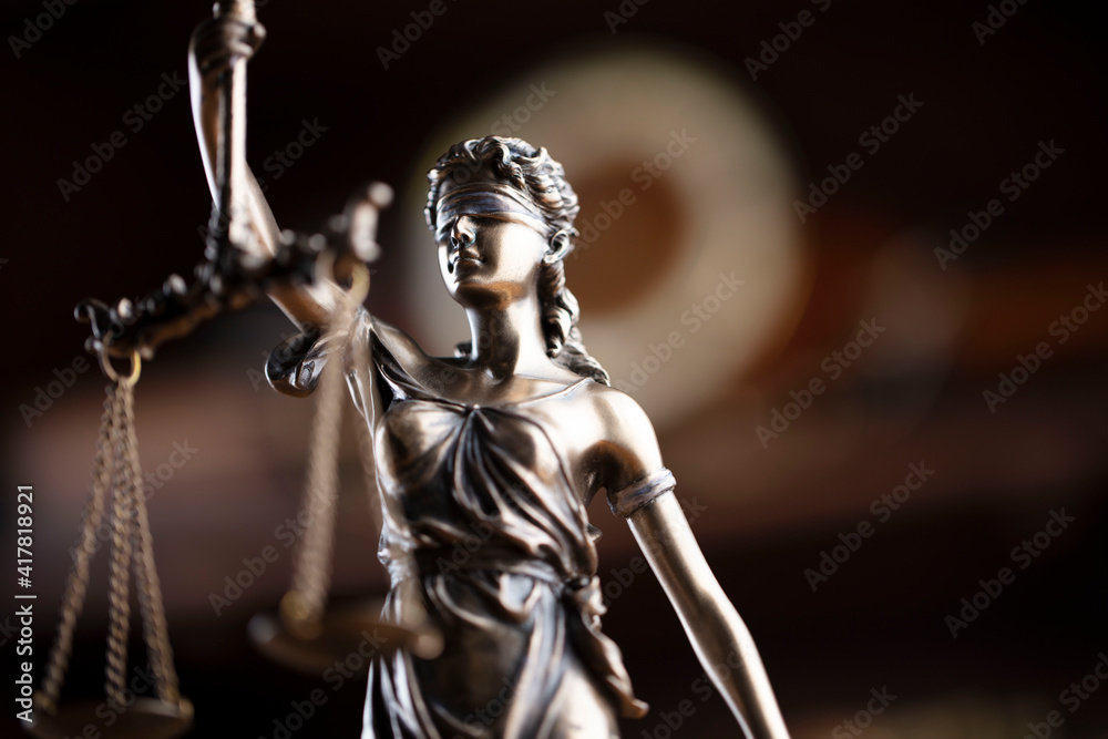 Law concept. Lawyer office. Themis statue on the shelf with legal books background. 