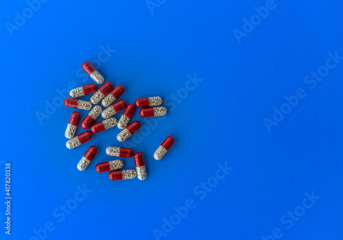 Various tablets and capsules, syringe, protective masks, on a blue background