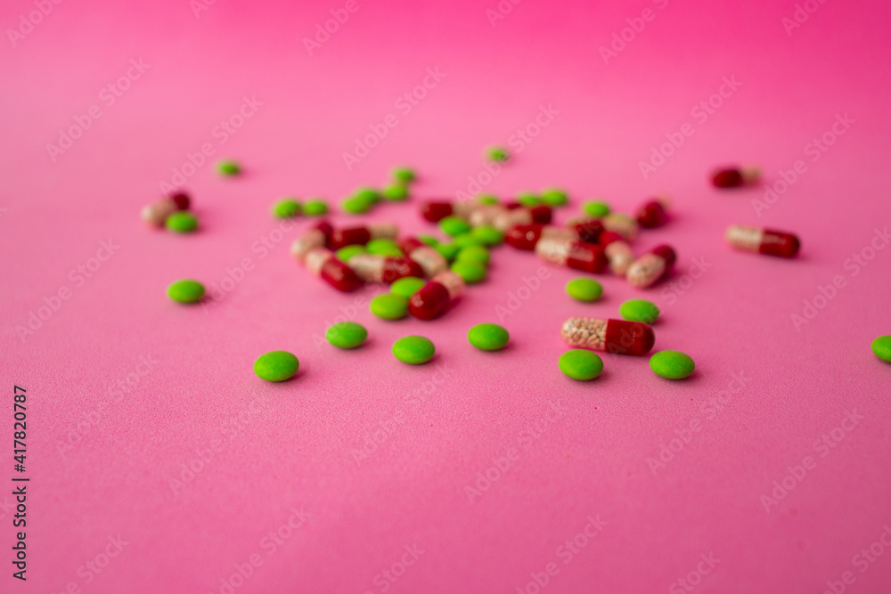 a bunch of different pills vitamins pills and capsules are lying on the table on a pink background close up view from above