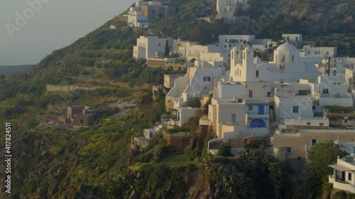 Aerial Pan of White Buildings in Plaka Village Milos Greece at Sunset photo
