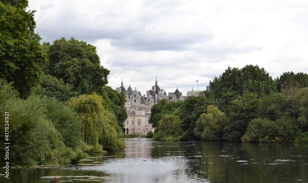 Scorcio di Londra all'orizzonte incorniciato da alberi fitti e verdi - vista dal fiume nel parco 