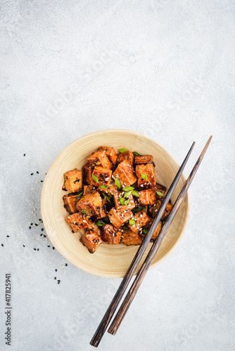 Marinated fried tofu cubes in bamboo bowl. Healthy vegan asian meal photo
