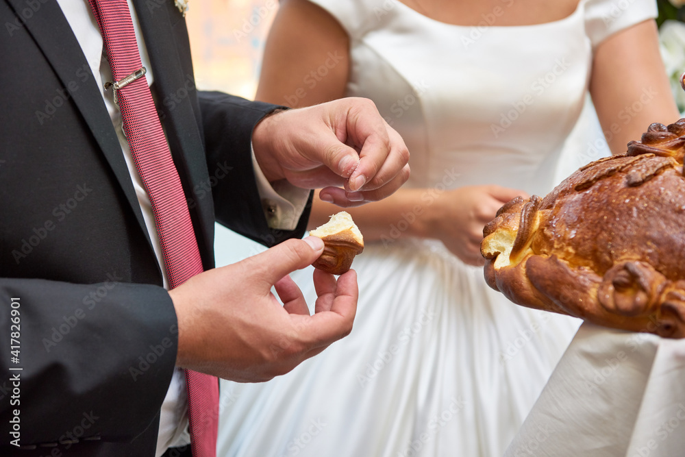 the bride and groom are eating a loaf. wedding traditions of russia the bride and groom are eating a loaf. wedding traditions of russia