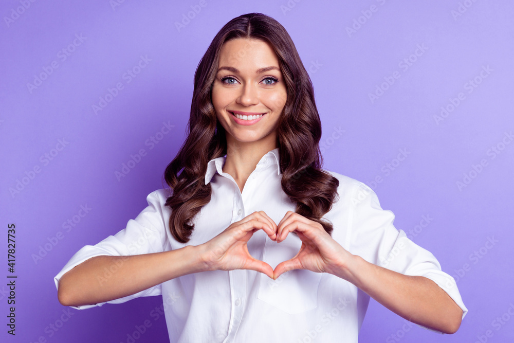 Photo of charming adorable lady fingers show heart figure wear white shirt isolated violet color background Photo of charming adorable lady fingers show heart figure wear white shirt isolated violet color background