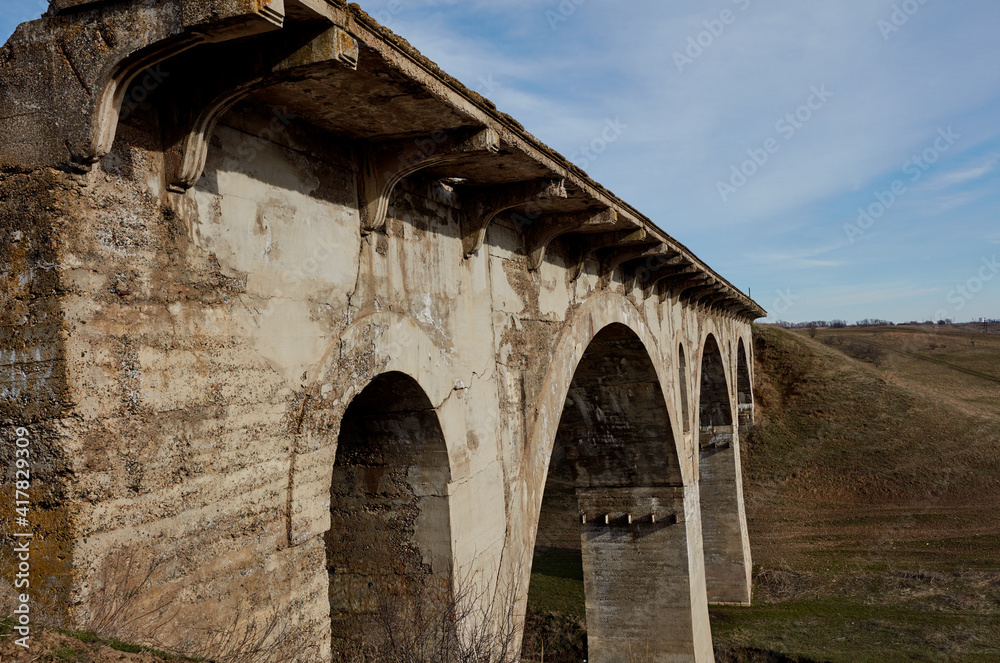 Old destroyed narrow-gauge railway bridge of the arched type