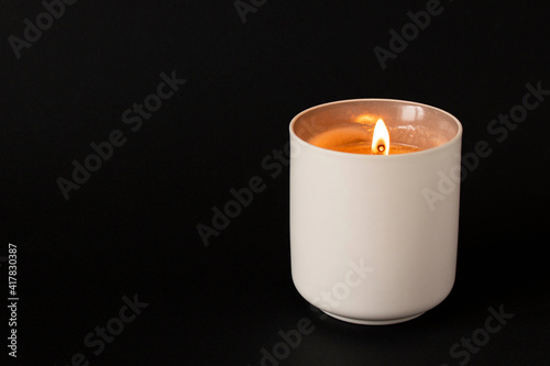 A burning candle on a dark background. Close-up. Selective focus.