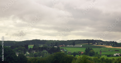 Rural village on a hill under cloudy sky.