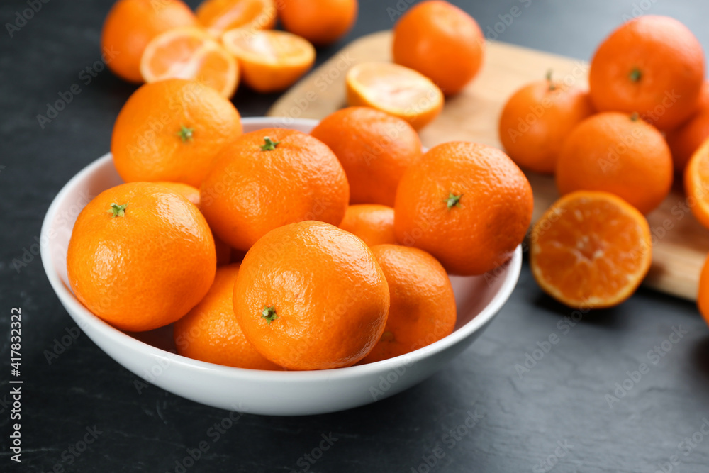 Fresh ripe tangerines on black table, closeup Fresh ripe tangerines on black table, closeup