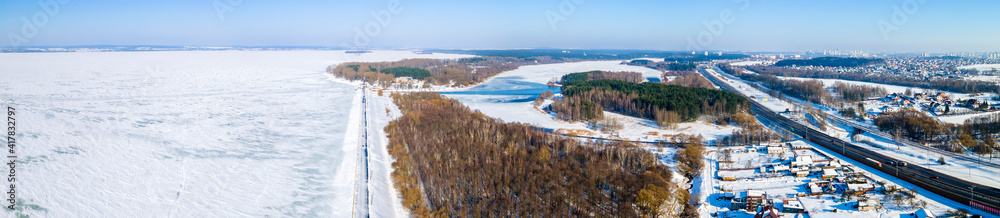 Aerial drone image of frozen lake and dam with snow. Ice from the drone view in winter. Beauty in nature concept.