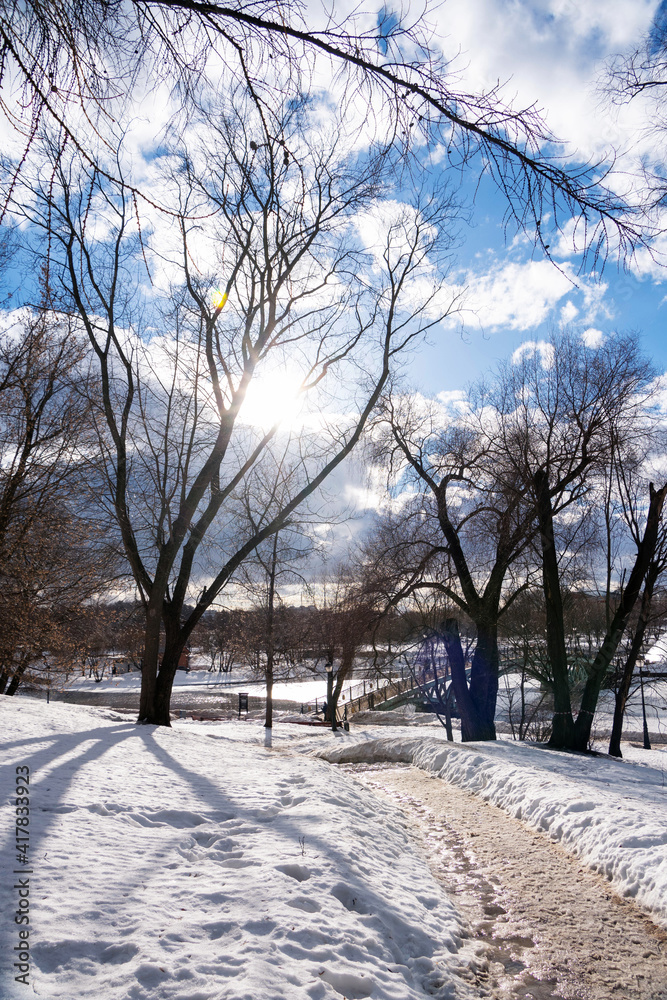 Winter landscape with bright sun in blue sky. Ice pond. The beginning of spring Winter landscape with bright sun in blue sky. Ice pond. The beginning of spring