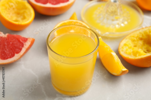 Freshly made orange juice, fruits and squeezer on table, closeup