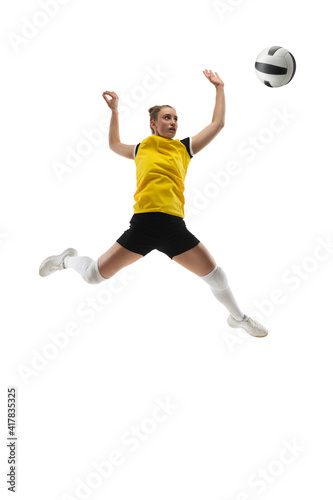 In jump. Young female volleyball player isolated on white studio background. Woman in sportswear training and practicing in action, flight. Concept of sport, healthy lifestyle, motion and movement.