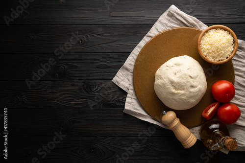 dough and ingredients for pizza on wooden background, top view
