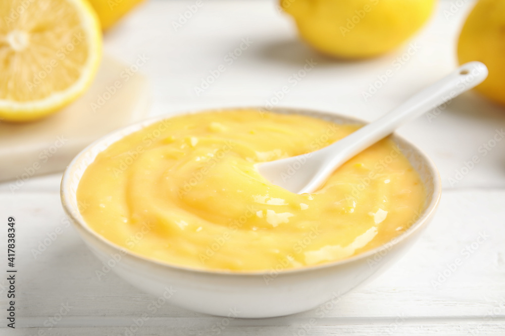 Delicious lemon curd in bowl on white wooden table, closeup Delicious lemon curd in bowl on white wooden table, closeup