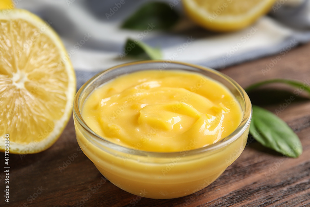 Delicious lemon curd in bowl on wooden table, closeup Delicious lemon curd in bowl on wooden table, closeup