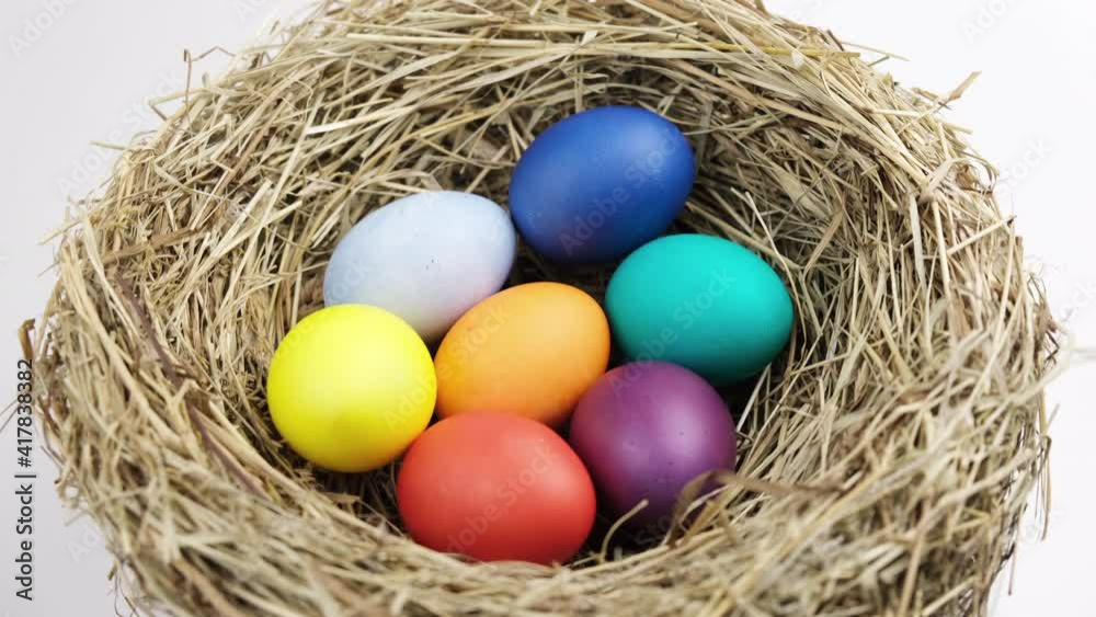 Easter multicolored rainbow eggs in a nest of hay spinning to the right, spring holidays concept Easter multicolored rainbow eggs in a nest of hay spinning to the right, spring holidays concept
