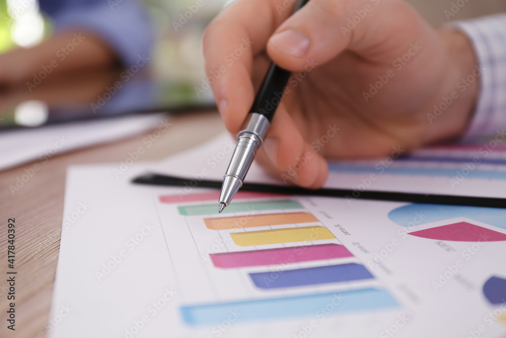 Business people working with charts and graphs at table in office, closeup. Investment analysis Business people working with charts and graphs at table in office, closeup. Investment analysis