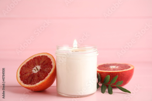 Wallpaper Mural Scented candle with burning wooden wick and cut grapefruit on pink table Torontodigital.ca