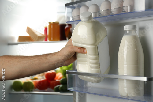 Man taking gallon of milk from refrigerator, closeup