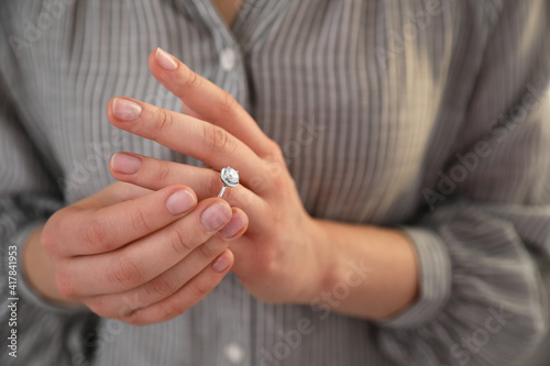 Woman taking off wedding ring, closeup. Divorce concept