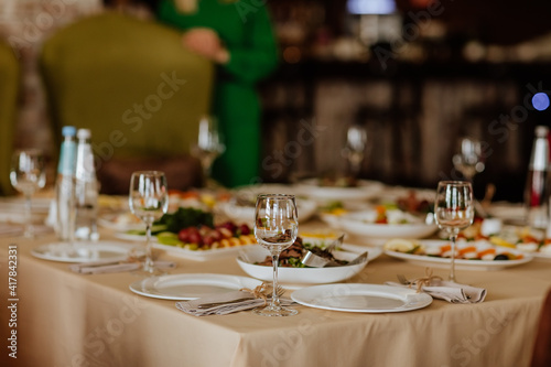 Dining tablecloth with food and glasses in the restaurant. Copy space.