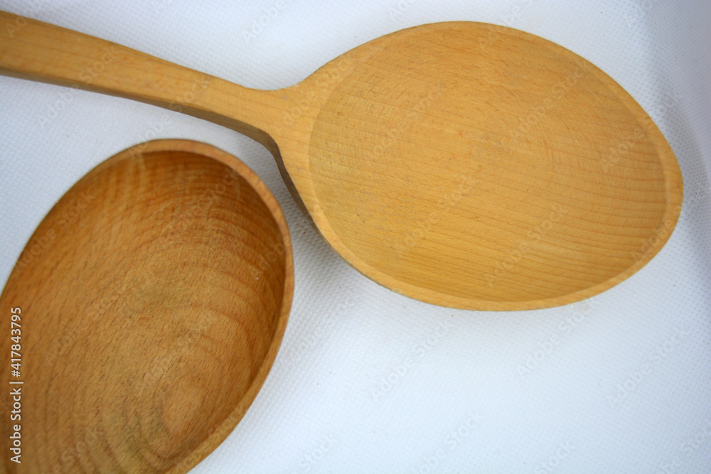 Two threaded Ukrainian spoons made of natural wood are located on a white background. Two threaded Ukrainian spoons made of natural wood are located on a white background.