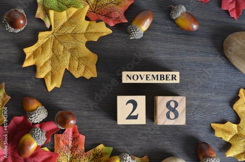 November 28, Cover Date design with Calendar cube decorate with maple leaf and Acorn Oak seed for your business.