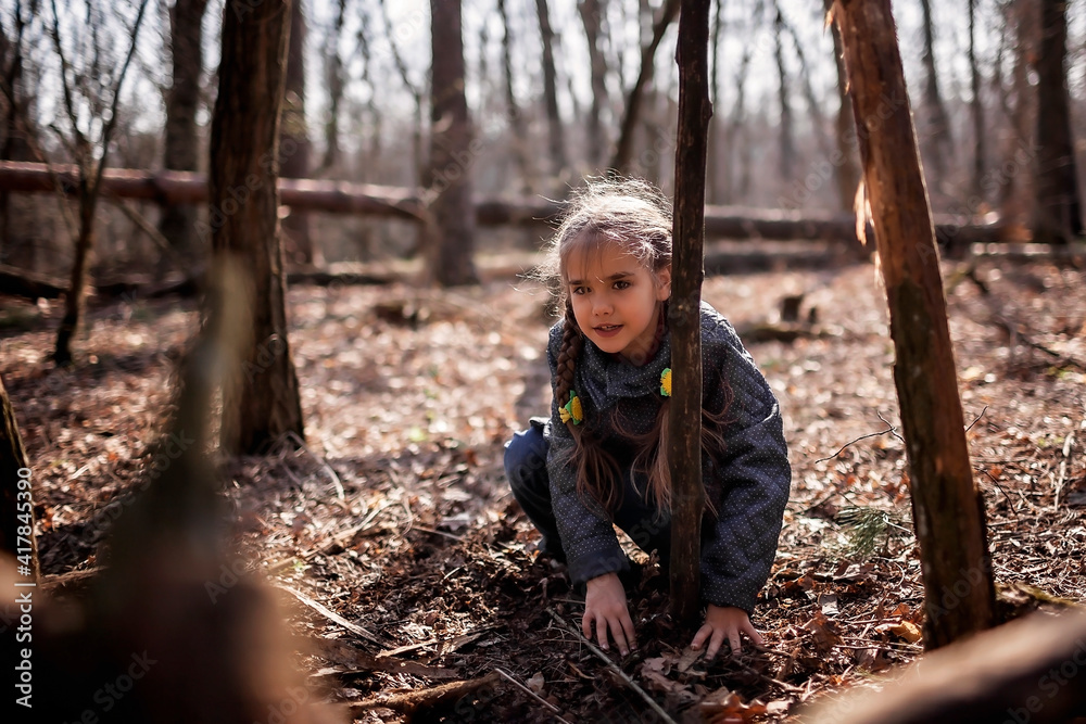 Young adventurers, boy and girl, building a wooden habitat in the wild forest during their social distant walking in lockdown time, walking on fresh air, outdoor active lifestyle Young adventurers, boy and girl, building a wooden habitat in the wild forest during their social distant walking in lockdown time, walking on fresh air, outdoor active lifestyle