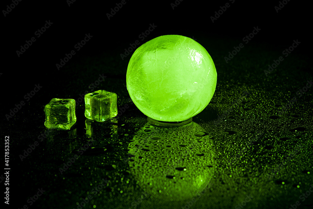 Green ice ball reflection on black background.