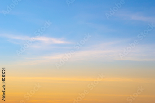Beautiful sky painted by the sun leaving bright golden shades.Dense clouds in twilight sky in winter evening.Image of cloud sky on evening time.Evening sky scene with golden light from the setting sun © Chalermwoot