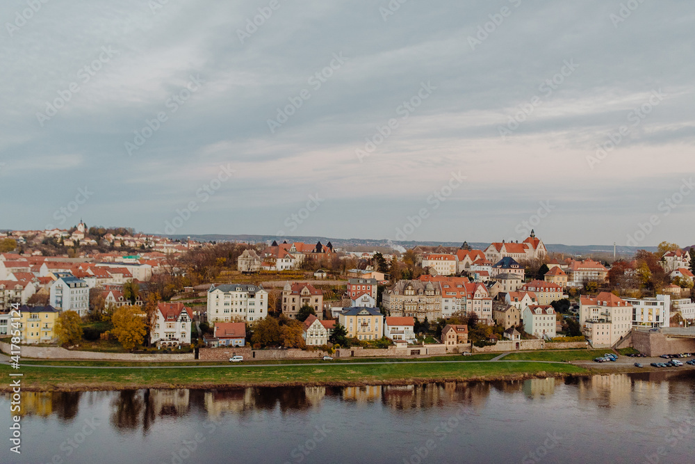 Obraz premium The red tile roofs of old European city Meissen on the embankment of river Elba