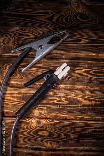 Welding wires on a wooden background. Place for the text. Studio photo in hard light.